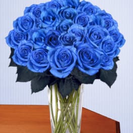 Blue roses arranged in a clear glass vase