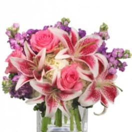 Pink roses and stargazer lilies in a clear glass vase