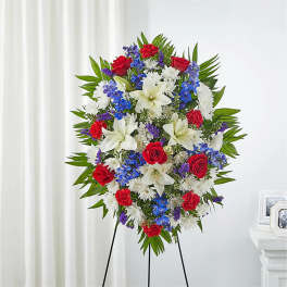 Standing floral spray with red, white, and blue flowers on an easel