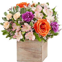 Mixed bouquet in a wooden box with orange and pink flowers