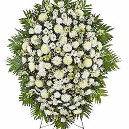 White funeral spray with daisies and roses on a stand