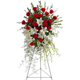 Standing floral spray of red roses and white lilies on an easel