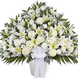 White funeral spray with lilies, roses, and chrysanthemums in a vase