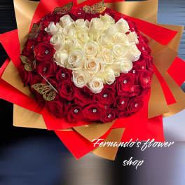 Large round bouquet of red and white roses with jeweled centers, wrapped in red and gold paper