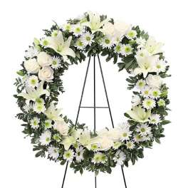 White floral wreath on a black easel stand