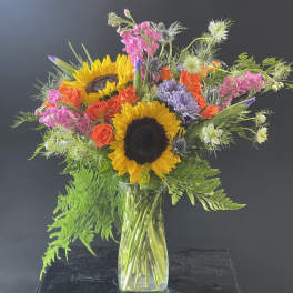 Sunflower and rose bouquet in a clear glass vase
