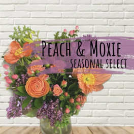 Peach and purple mixed flower arrangement in a glass vase