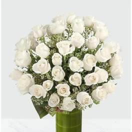 White rose bouquet in a tall green glass vase