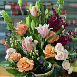 Mixed bouquet with roses, tulips, and lilies in a ceramic bowl