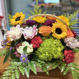 Basket arrangement with sunflowers, roses, hydrangea, and carnations