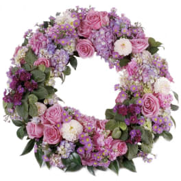 Circular wreath of pink and purple flowers with green foliage