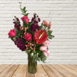 Mixed bouquet in a glass vase with pink roses and red anthurium