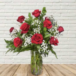 Red roses and white baby's breath in a clear glass vase