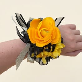 Yellow flower wrist corsage with black and silver ribbon accents