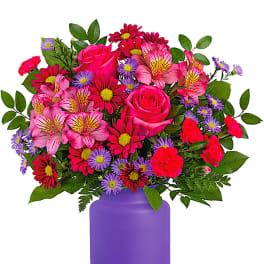 Mixed pink and purple flowers in a purple vase