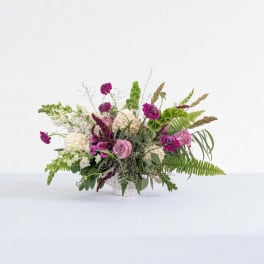 Mixed pink and white floral arrangement in a white container