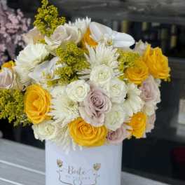 Bouquet of yellow, white, and blush roses in a white box