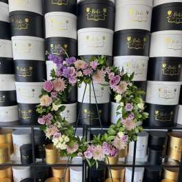Floral wreath on a metal stand with pink and lavender flowers