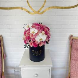 Pink rose arrangement in a navy cylindrical box with white orchids