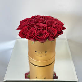 Red roses arranged in a gold round box