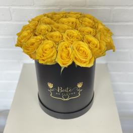 Yellow roses arranged in a black round box