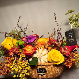 Colorful flower arrangement in a wicker basket with roses and berries