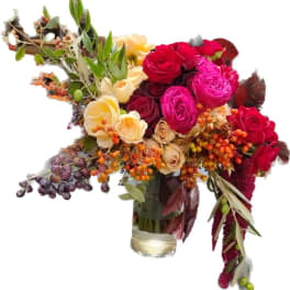 Bouquet of red, pink, and cream roses in a glass vase