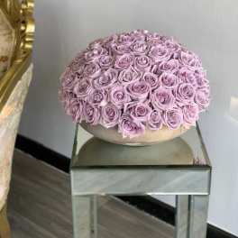 Round arrangement of lavender roses in a low bowl