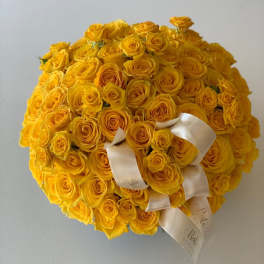 Large round bouquet of yellow roses with white ribbon