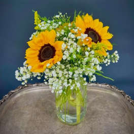 Sunflowers and white baby's breath in a clear glass vase