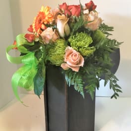 Bouquet of roses, gerbera daisy, and green chrysanthemums in a black vase