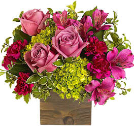 Pink roses and magenta alstroemeria in a wooden box