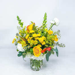 Yellow and white mixed flower arrangement in a clear glass vase