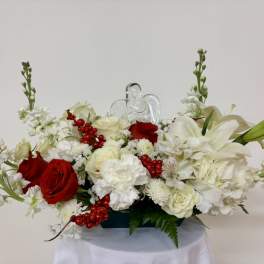 Red and white floral arrangement with a clear angel figurine
