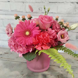 Pink mixed flower arrangement in a pink container