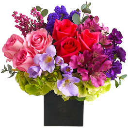 Colorful bouquet of roses, orchids, and hydrangeas in a black vase
