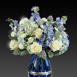 Blue and white floral arrangement in a cobalt glass vase