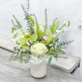 White and green floral arrangement in a white vase
