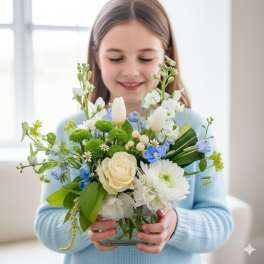 Girl holding a mixed bouquet in a glass vase