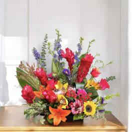 Bright mixed flower arrangement in a low black container