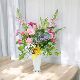 Mixed pink and yellow flower arrangement in a white vase