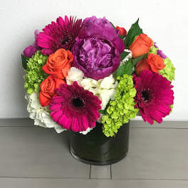 Bright mixed bouquet in a black vase with pink, purple, orange, and white blooms