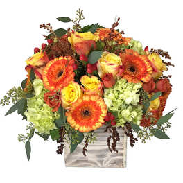 Orange gerberas and yellow roses in a wooden box