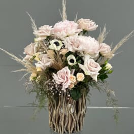 Blush rose arrangement in a tall decorative vase