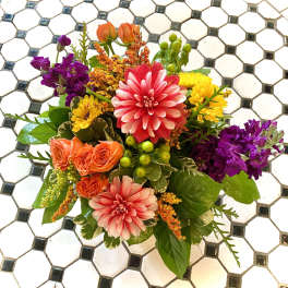 Colorful mixed bouquet with pink dahlias, orange roses, and purple blooms