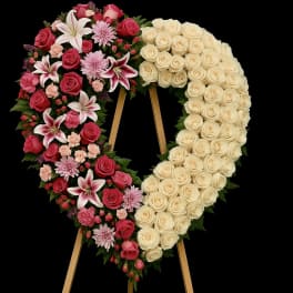 Large heart-shaped standing wreath of cream roses and pink mixed flowers on an easel