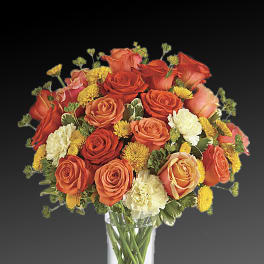 Orange and yellow rose bouquet in a clear glass vase