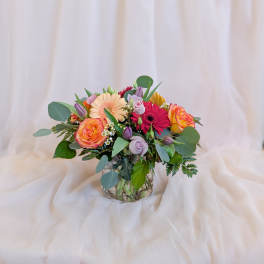 Mixed bouquet in a clear glass vase with roses and gerbera daisies