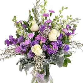Purple and white bouquet in a clear glass vase