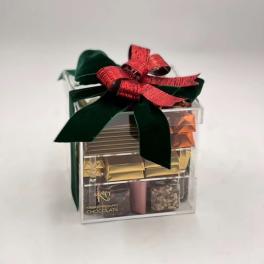Clear gift box of assorted chocolates tied with a red and green ribbon